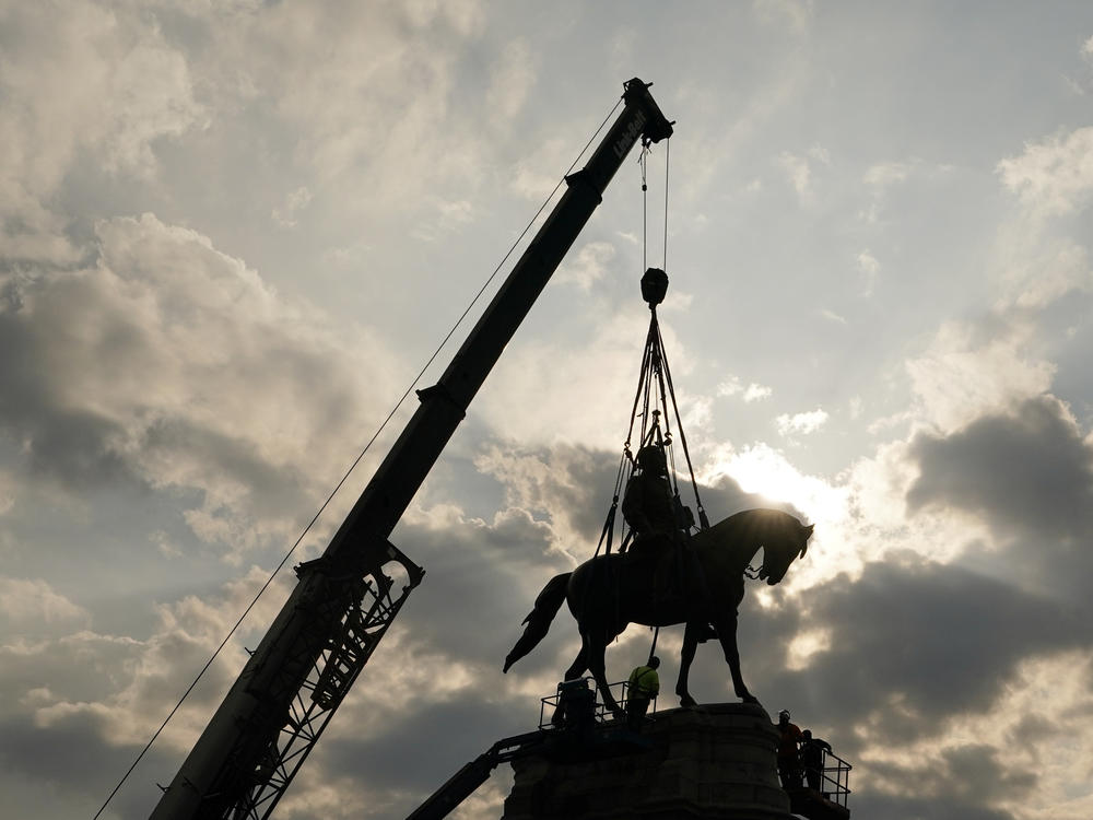 Crews work to remove one of the country's largest remaining monuments to the Confederacy, a towering statue of Confederate Gen. Robert E. Lee on Wednesday in Richmond, Va.