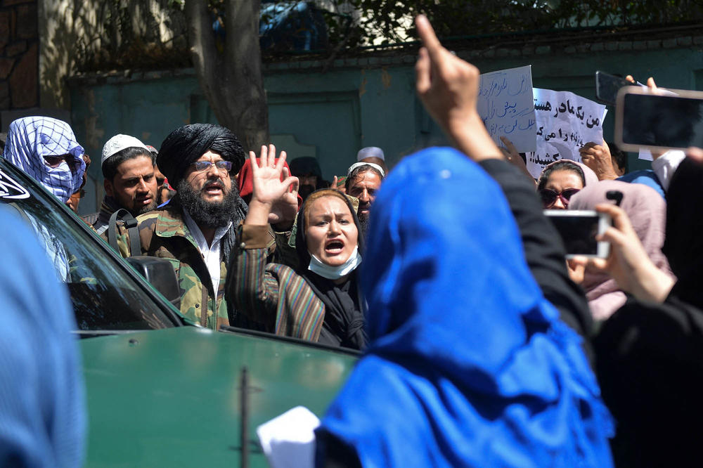 Afghan women chant slogans in front of Taliban fighters during an anti-Pakistan demonstration near the Pakistani Embassy in Kabul on Tuesday. The Taliban fired shots into the air to disperse crowds.