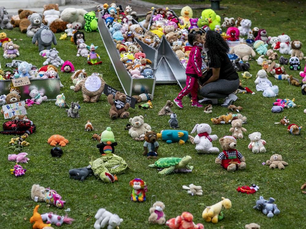A young girl and her mother visit a temporary art installation, called Bear the Truth, on June 28, 2020, at the Los Angeles City Hall. The installation honors Black children who have lost their lives to racial injustice and senseless violence.