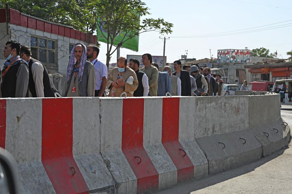 Airport workers stand in a queue at a checkpoint before entering Kabul International Airport in Kabul on Sept. 4.