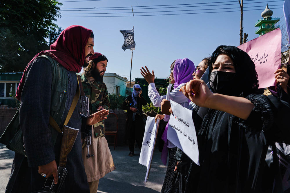 Taliban members try to stop the advance of protesters marching through Kabul's Dasht-e-Barchi neighborhood on Wednesday.