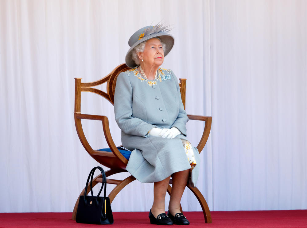 Queen Elizabeth II watches a flyover by the RAF Red Arrows during a military parade, held by the Household Division at Windsor Castle, to mark her official birthday on June 12, 2021, in Windsor, England.