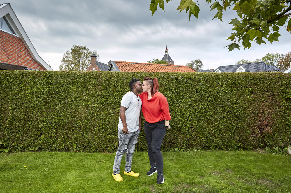 Patrick Phiri of Malawi and fiancée Fiona ten Have of the Netherlands kiss in her parents' garden. The couple met in Malawi, where they worked for the same charity, and fell in love. A three-week visit to the Netherlands turned into seven months because of pandemic lockdowns and travel restrictions.