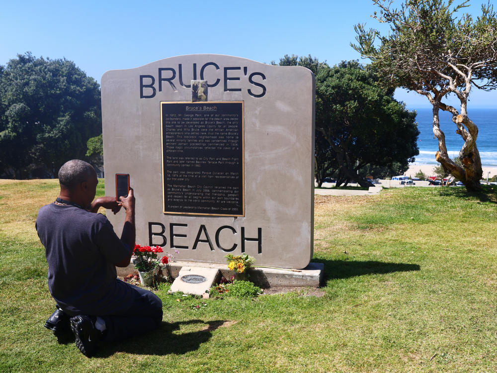 William Redmond III, a visitor from Atlanta, takes a photo of the historic plaque marking Bruce's Beach in April in Manhattan Beach, Calif.