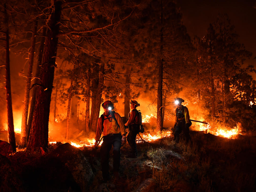 Firefighters battle the Caldor Fire this month along Highway 89 west of Lake Tahoe in California.