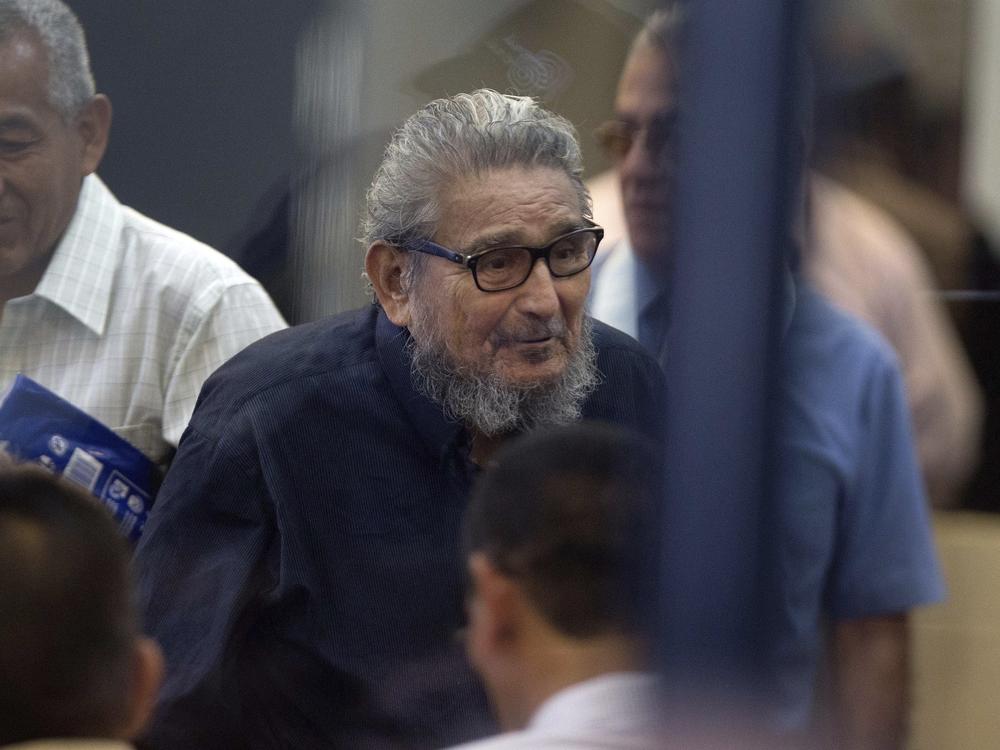 In this Feb. 28, 2017 file photo, Abimael Guzman, founder and leader of the Shining Path guerrilla movement, center, enters a courtroom at the Naval Base in Callao, Peru.