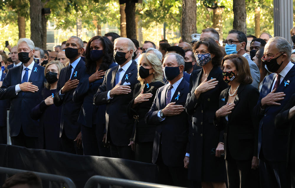 Former President Bill Clinton (from left), former first lady Hillary Clinton, former President Barack Obama, former first lady Michelle Obama, President Biden, first lady Jill Biden, former New York Mayor Michael Bloomberg, his partner Diana Taylor, House Speaker Nancy Pelosi and Senate Majority Leader Charles Schumer stand for the national anthem at Saturday's ceremony in New York City.