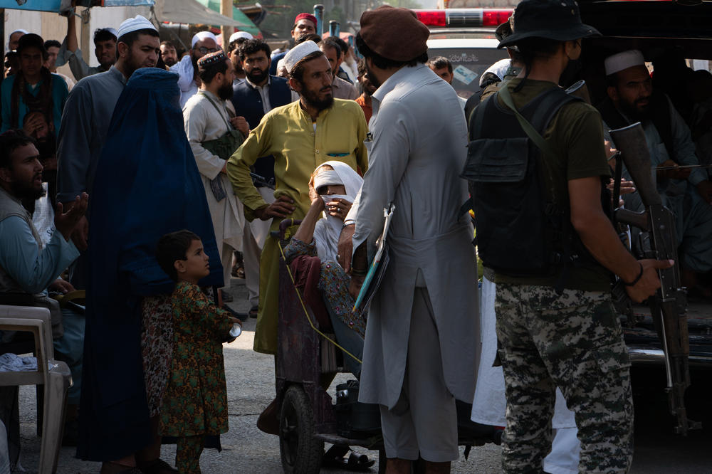 People seeking medical attention wait on the border to enter Pakistan.