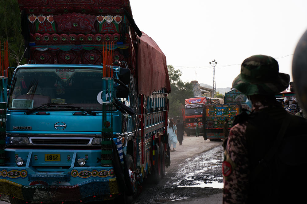 A brightly painted truck passes through Torkham while a Pakistani guard watches.