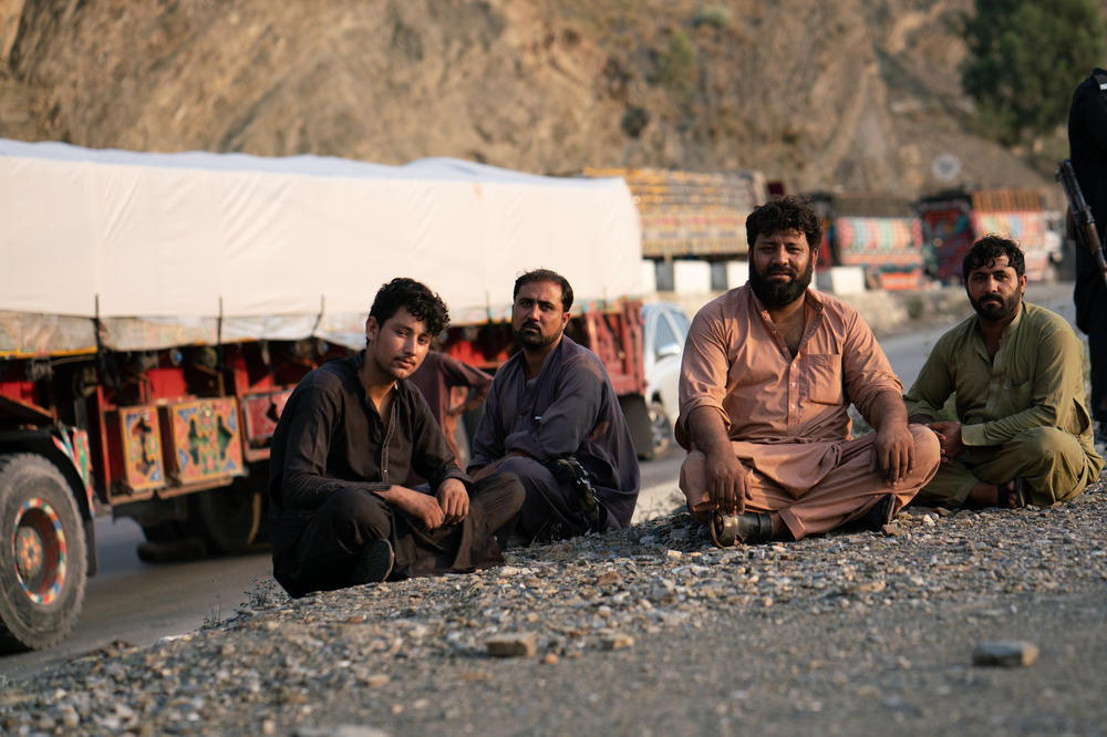 Razziq Mehmon (second from right) waits in Pakistan near the border to drive a truck loaded with cement bound for Jalalabad, Afghanistan.