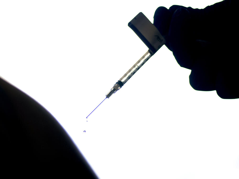 A droplet falls from a syringe after a health care worker was injected with the Pfizer COVID-19 vaccine last year at a hospital in Providence, R.I.