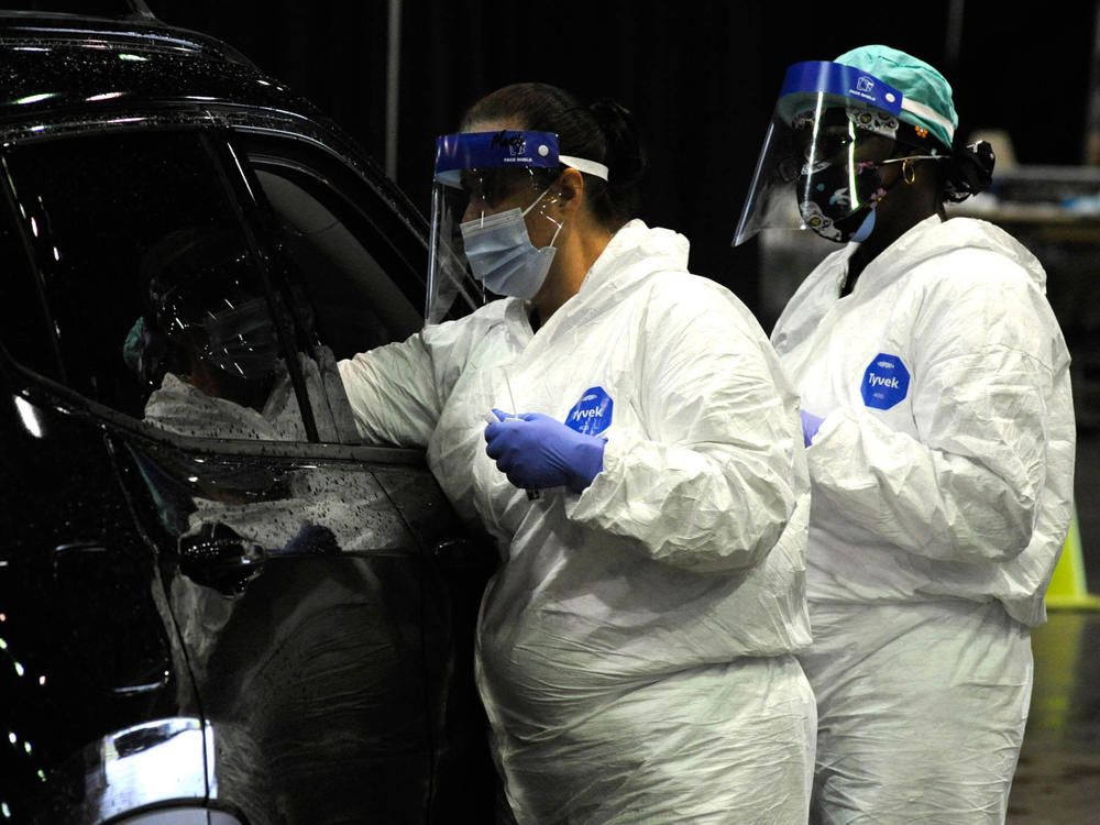 A medical worker tests a person for COVID-19 last month in Mobile, Ala. A surge of coronavirus cases in the state has stretched hospital ICUs to capacity, making it difficult for patients with other conditions to find ICU beds.
