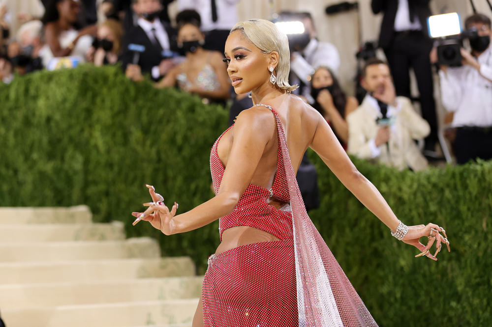 Saweetie told red carpet host Keke Palmer that her Christian Cowan caped dress is inspired by the Black American heritage flag and the Filipino flag.