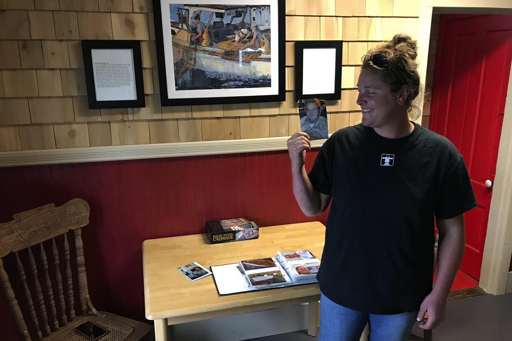 Lobsterman Meredith Oliver with a photo of her grandfather Lee, who taught her to fish and whose lobster boat she inherited at age 15 after his death. Now she's 28 and her plan is to do whatever it takes to keep lobstering.