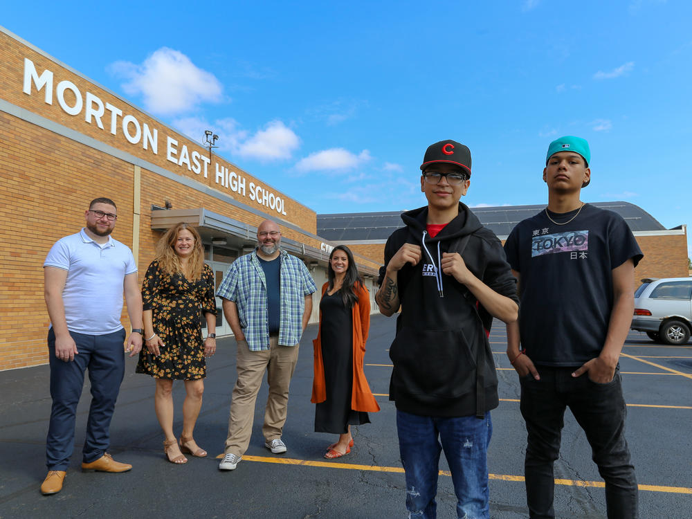 <strong>From left to right:</strong> Teachers Mark Sujak, Sarah Lorraine, Jeremy Robinson and Sophia Faridi pose with students and podcast finalists Julian Fausto and Eric Guadarrama for portraits in front of Morton East High School, in Cicero, Ill.