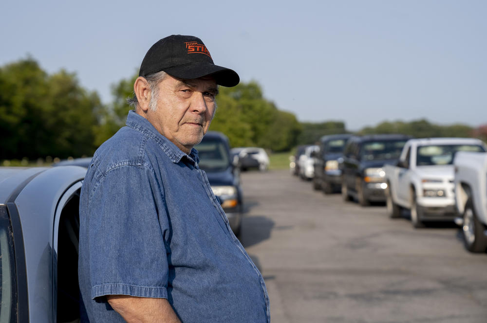 Lloyd Abshier, 70, stands outside his car waiting for a drive-through food distribution event to begin in Columbia, Tenn. Abshier arrived over two hours early to get food for his wife and two kids.