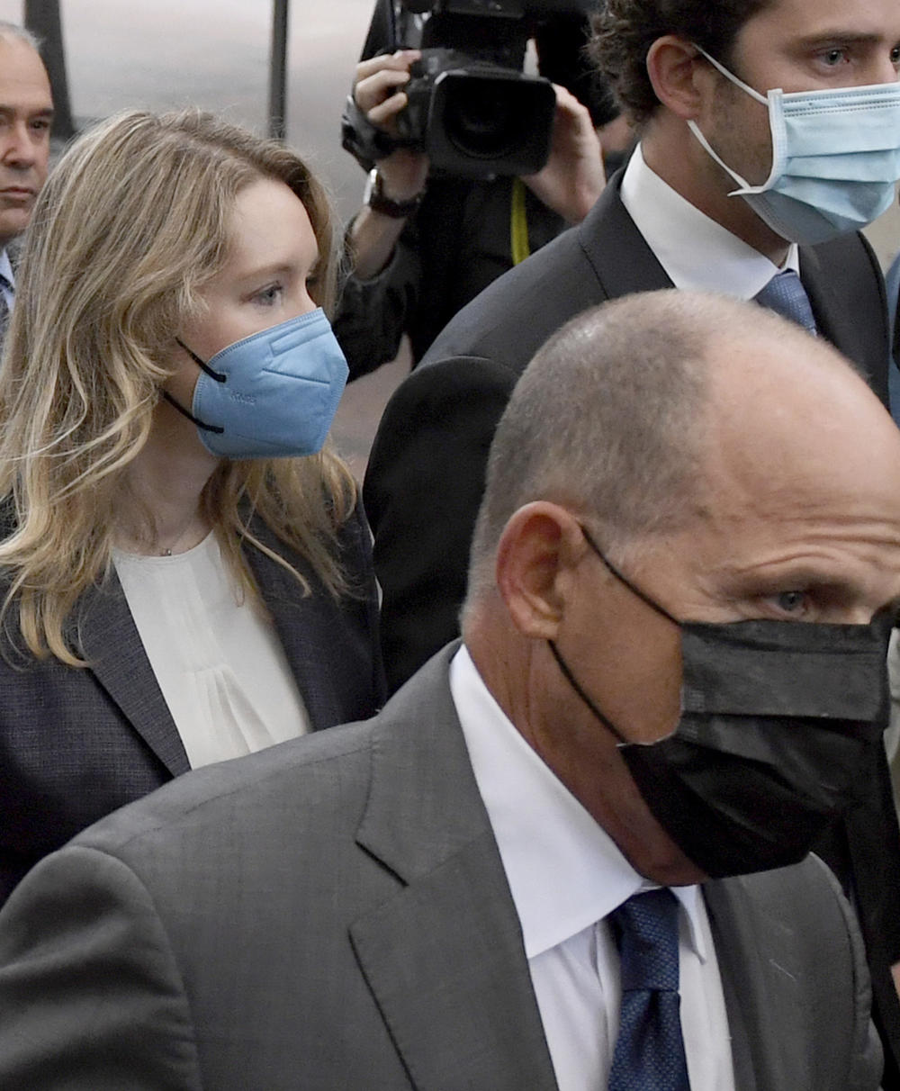 Even before his unmasking, Bill Evans (right), with Elizabeth Holmes, had left some clues for reporters that he was not a car enthusiast just crossing off his bucket list item of attending a trial.