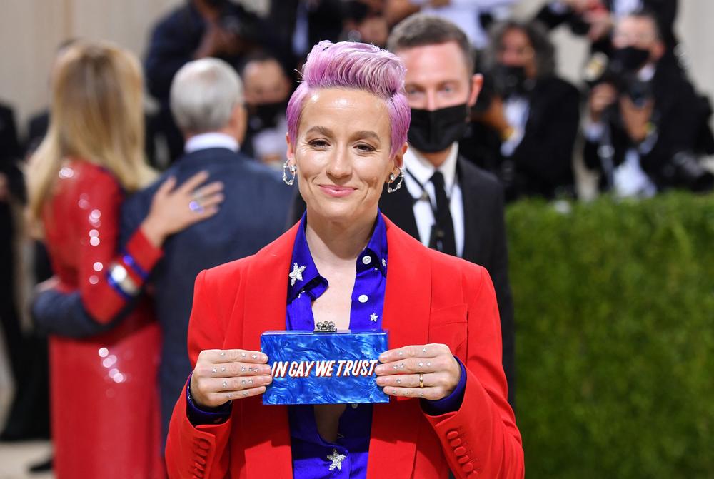 U.S. soccer player Megan Rapinoe holds up her bag at the entrance to the Met Gala.