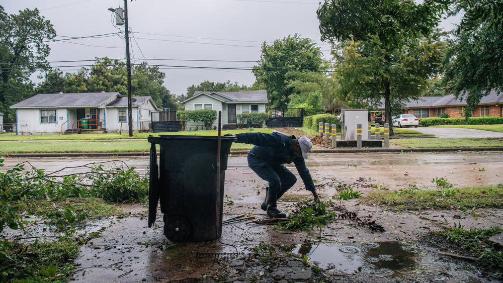 Dallas Baines, 77, clears fallen tree branches Tuesday after Tropical Storm Nicholas moved through the Houston area. The storm will likely slow down as it heads to Louisiana, where parts of the state continue to cope with Hurricane Ida's aftereffects.