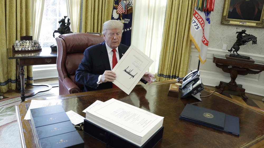 Then-President Donald Trump displays the $1.5 trillion tax overhaul package he signed in December 2017.