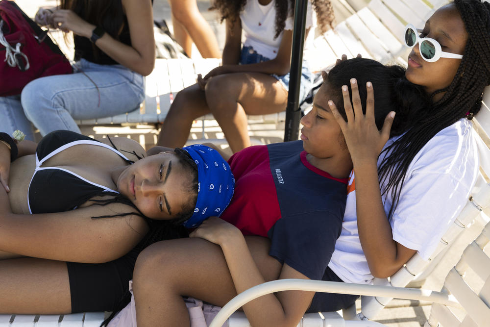 Sophia and Sylvie rest on Tewa at the pool.