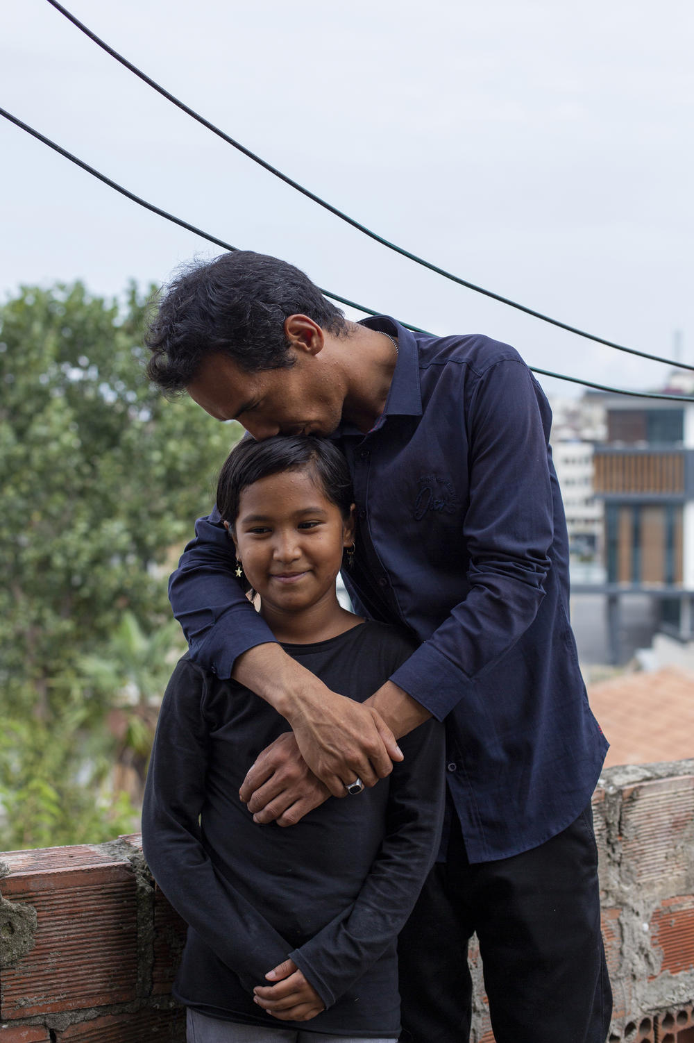 Sayyid Ali Hussaini kisses his 9-year-old daughter Elisa. 