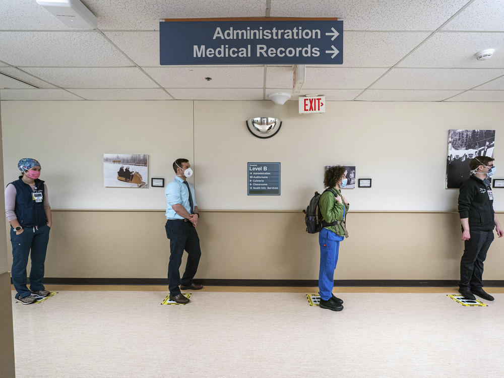 Front-line caregivers wait in line to receive a Pfizer-BioNtech COVID-19 vaccine in December at Providence Alaska Medical Center in Anchorage, Alaska.