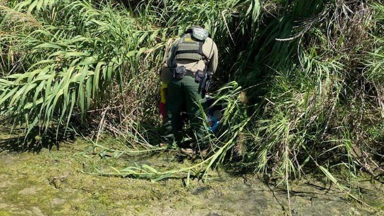 An agent from the U.S. Border Patrol checks on the toddler girl and infant boy who were discovered along the Rio Grande near Eagle Pass, Texas.