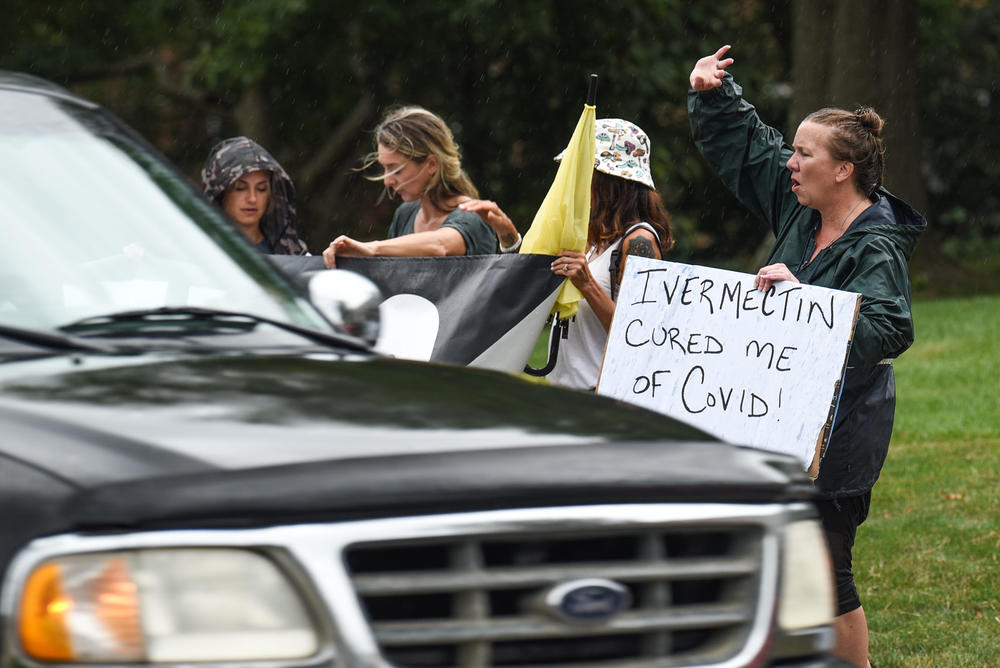 Protesters for an anti-vaccine rally in Cincinnati in August carry a sign backing ivermectin. Belief in the drug's efficacy often goes hand in hand with vaccine hesitancy.