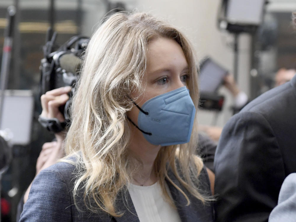 Elizabeth Holmes (center) walks into the federal courthouse for her trial in San Jose, Calif., on Wednesday.