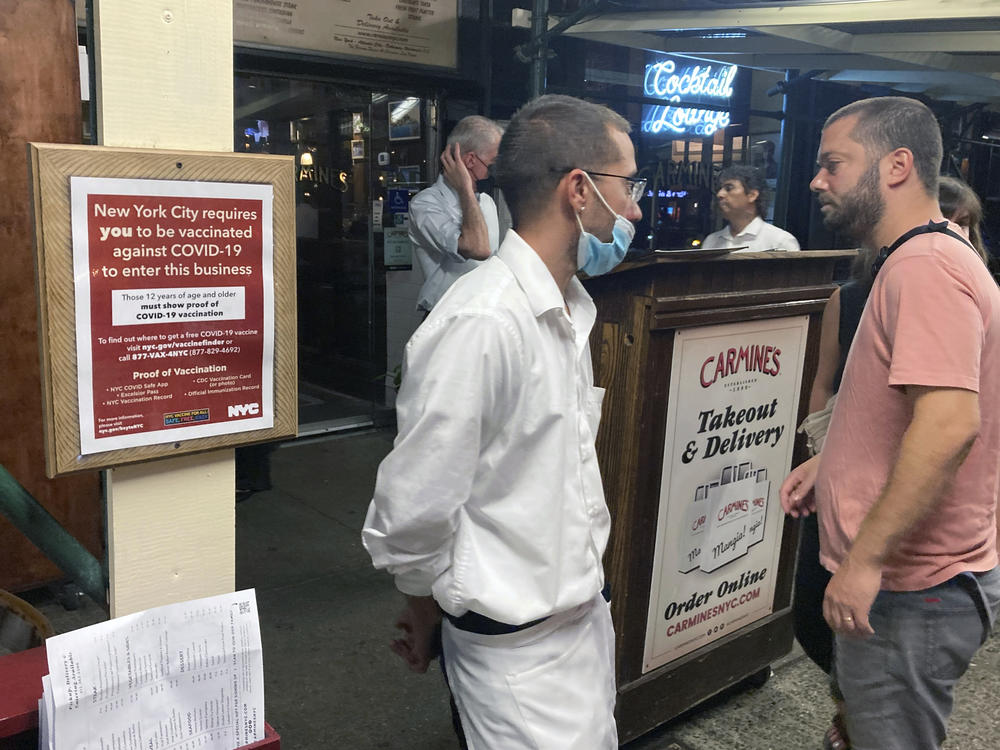 A sign in August informs customers that they must show proof of vaccination against COVID-19 in order to dine indoors at Carmine's Italian restaurant in Manhattan.