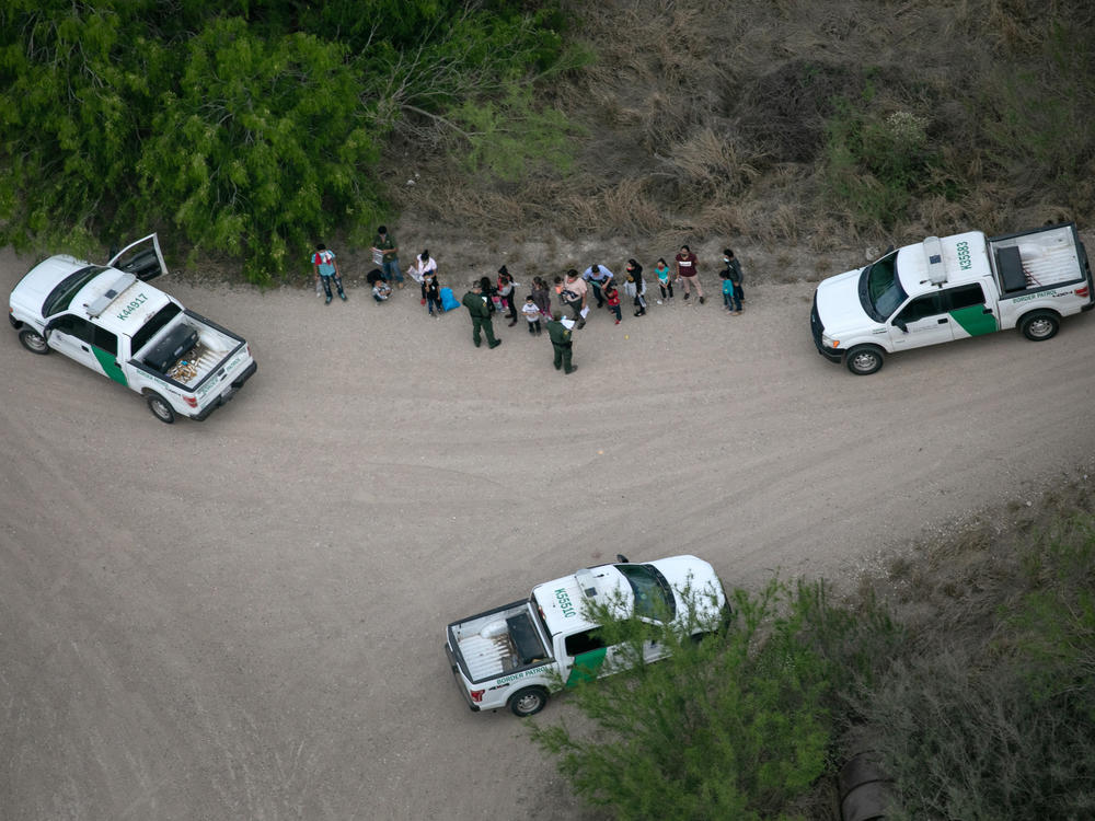 U.S. Border Patrol agents take asylum-seekers into custody as seen from a Texas Department of Public Safety helicopter near the U.S.-Mexico border on March 23 in McAllen, Texas.