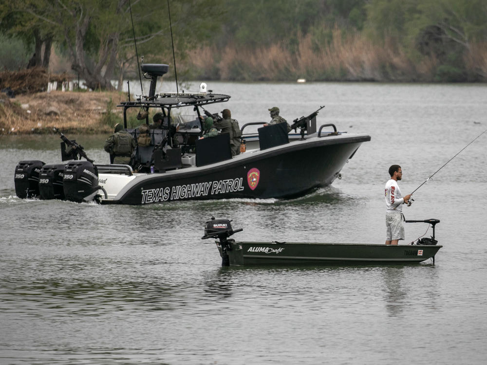 A Texas Department of Public Safety boat passes a Mexican fisherman on the Rio Grande on March 24 near Mission, Texas. Texas DPS troopers are taking part in Operation Lone Star.