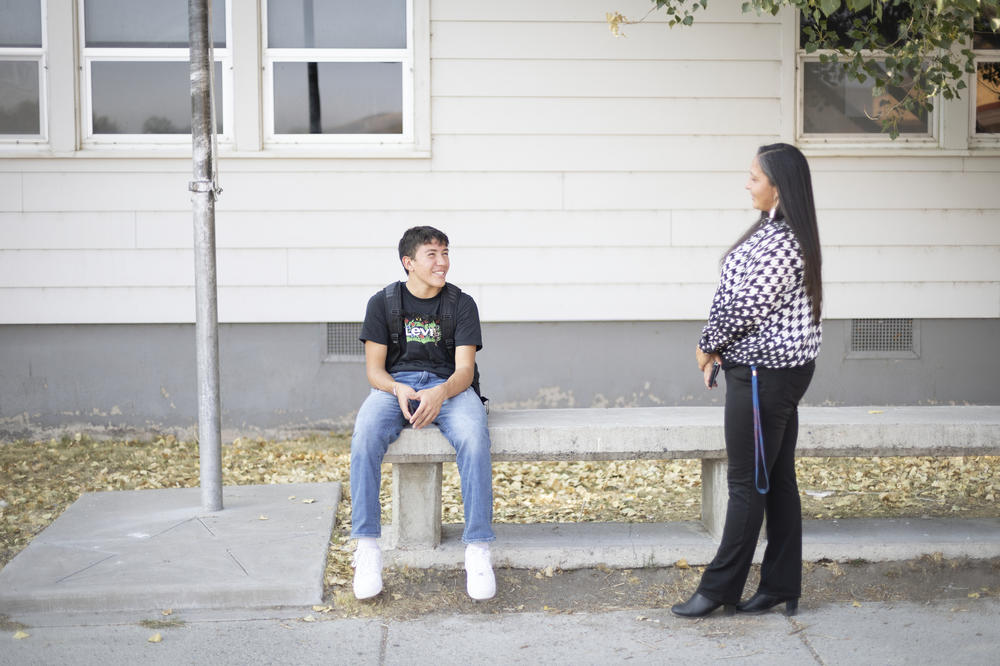 Owyhee vice principal Lynn Manning-John talks with her son, Bisaapi Melendez, outside of the school building.