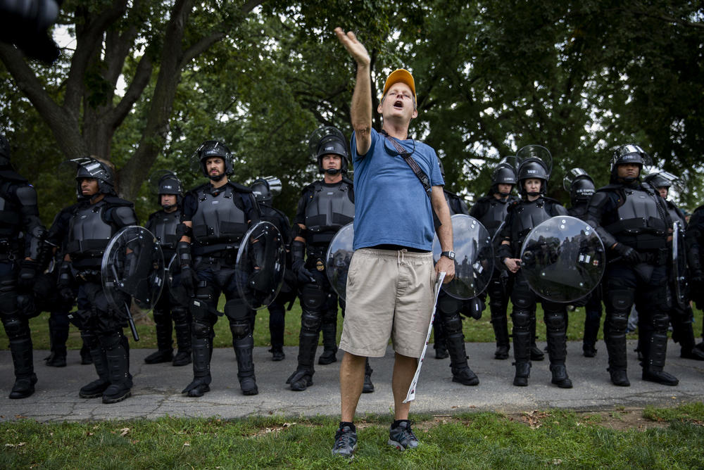 Counterprotester Eric Lamar from Washington, D.C. stands in front of a line go Capitol Police.