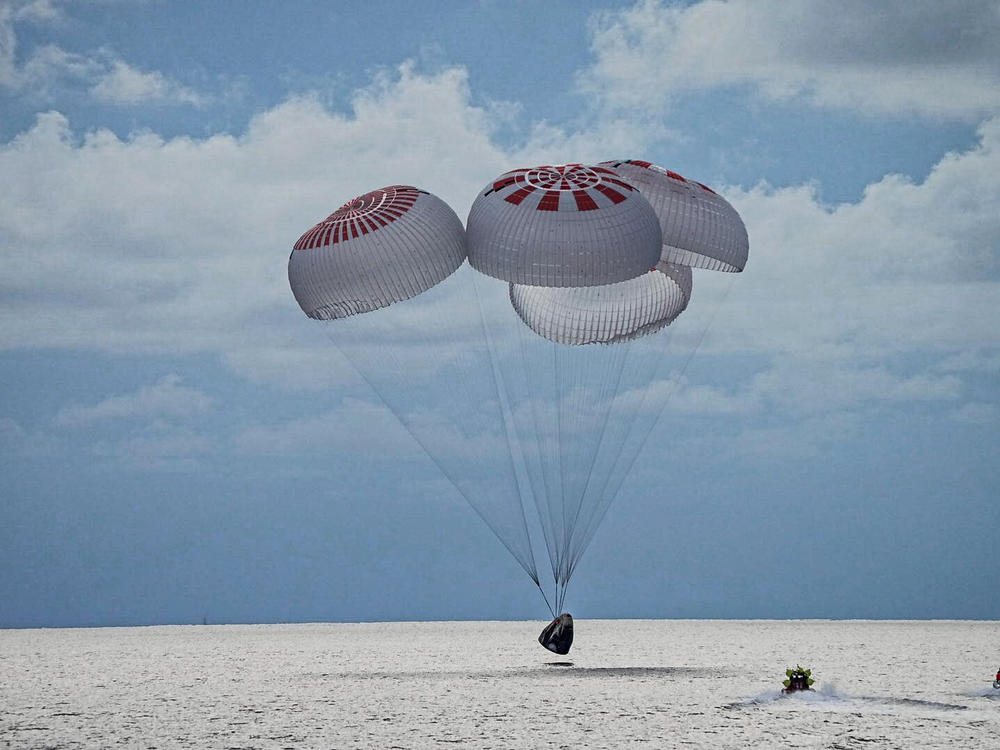 In this image provided by SpaceX, a capsule carrying the all-amateur Inspiration4 crew parachutes into the Atlantic Ocean off the Florida coast on Saturday, Sept. 18, 2021.