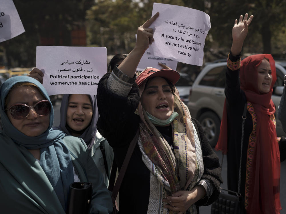 Women march to demand their rights under the Taliban rule during a demonstration near the former Women's Affairs Ministry building in Kabul, Afghanistan, on Sunday. The interim mayor of Afghanistan's capital said that many female city employees have been ordered to stay home by the country's new Taliban rulers.