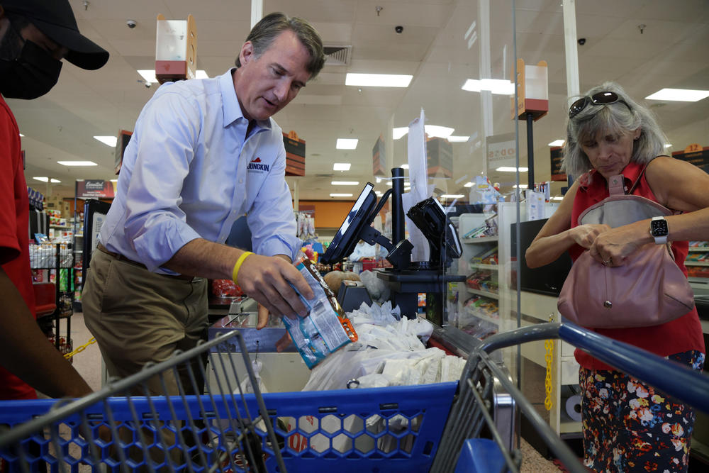 Virginia Republican gubernatorial candidate Glenn Youngkin bags groceries for a customer during a campaign stop at Hispanic-owned supermarket Todos on Sept. 15 in Woodbridge, Va. Youngkin is trying to make inflation a focus of the campaign, pledging to repeal Virginia's grocery tax.