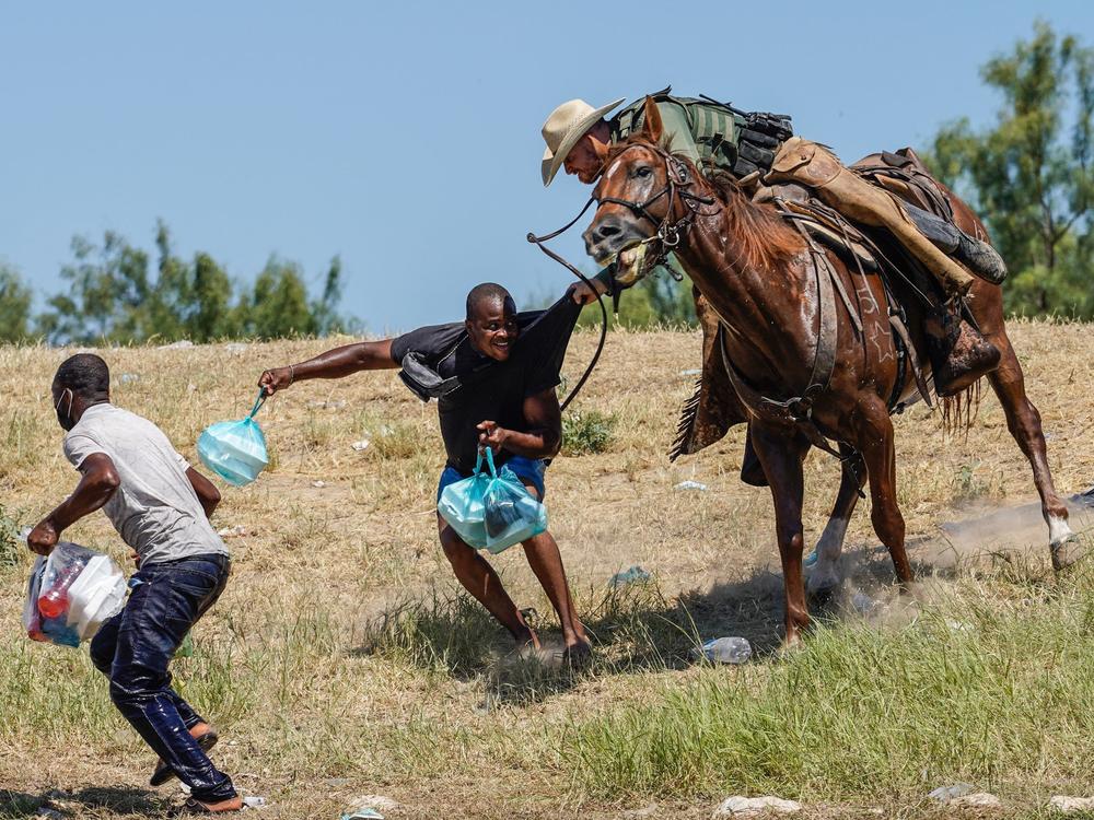 A U.S. Border Patrol agent on horseback tries to stop a Haitian migrant from entering an encampment on the banks of the Rio Grande on Sunday near the international bridge in Del Rio, Texas.