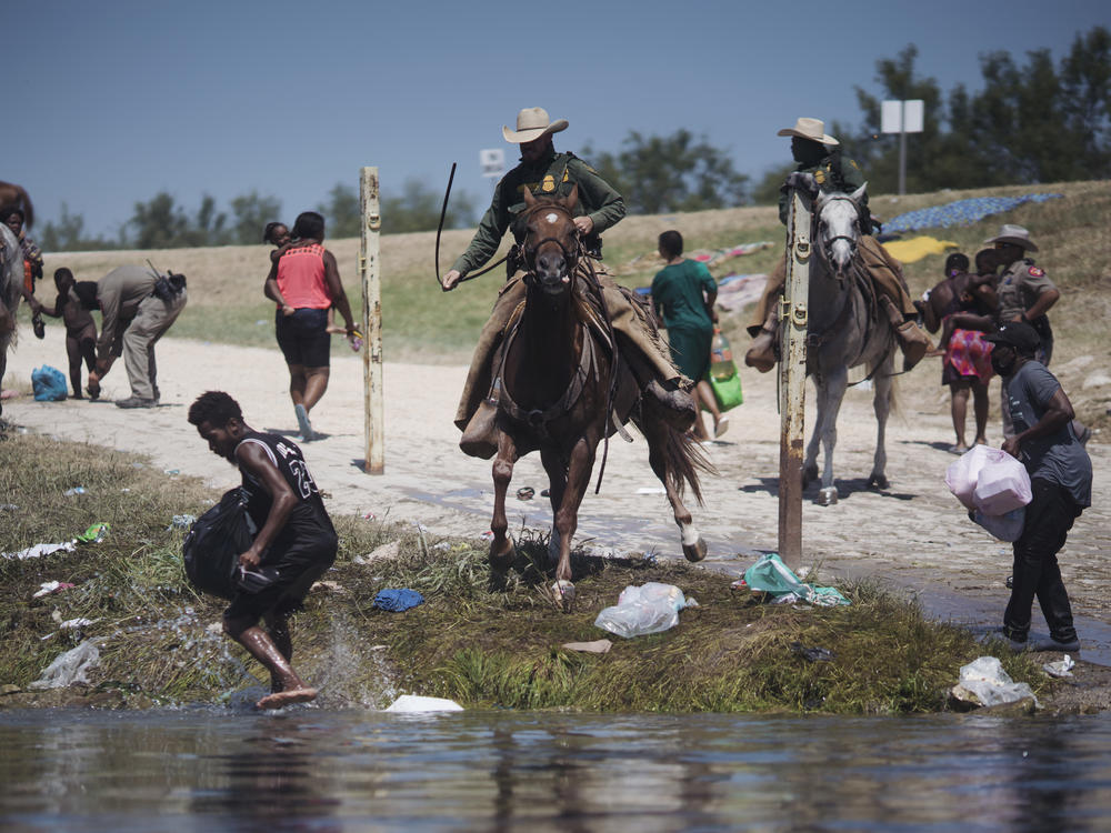 Border Patrol agents stop migrants crossing the Rio Grande on Sunday near the port of entry in Del Rio.