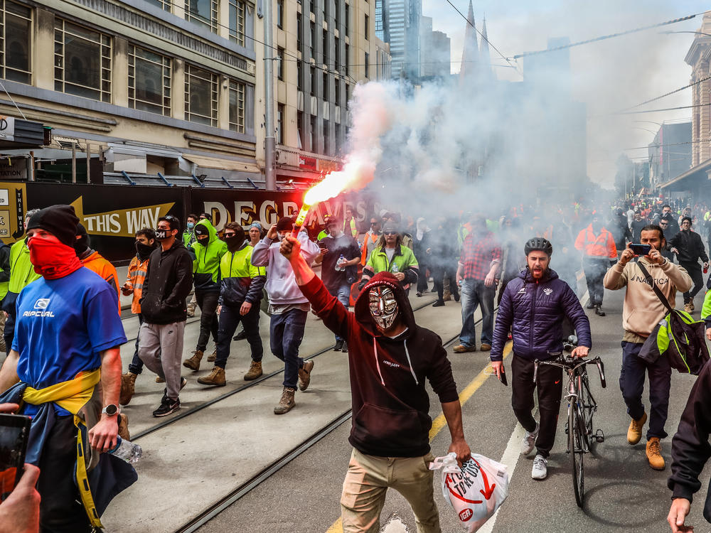 Protesters march through Melbourne, Australia, on Tuesday over recently announced COVID-19 vaccine requirements for construction workers. Construction sites have been shut down for two weeks due to protests and rising COVID-19 cases.