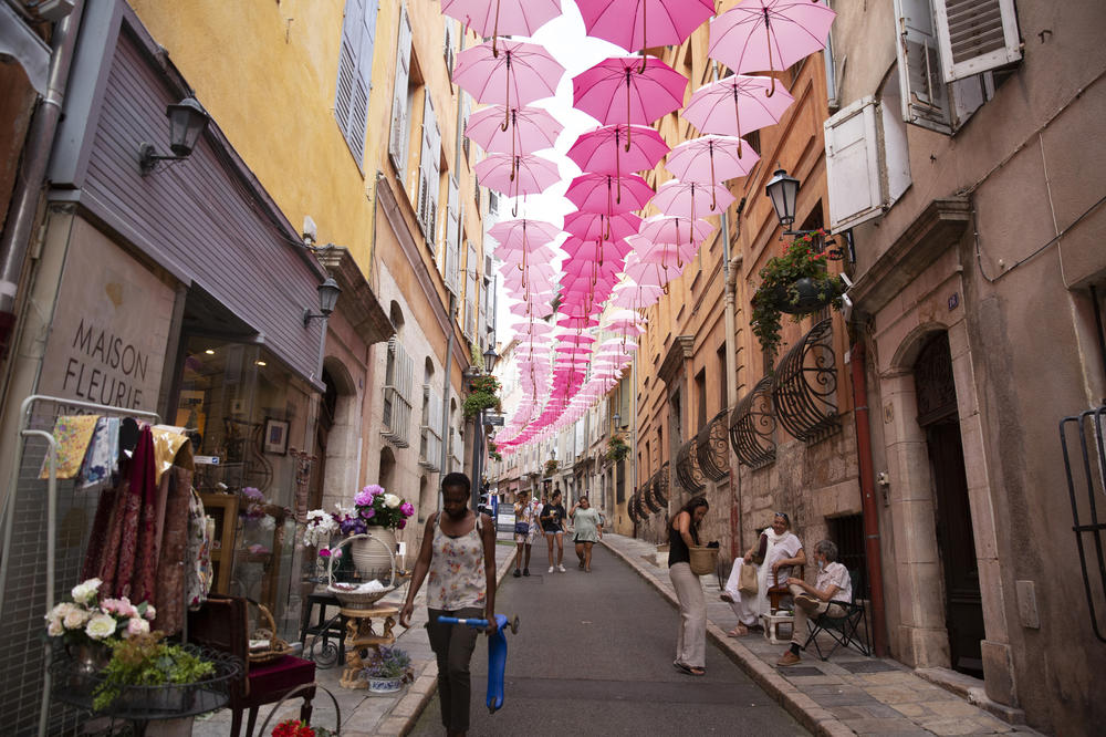 The historic center of Grasse was once home to perfume factories that have since moved out of the old town. Pink umbrellas are suspended above the streets every May through October, representing the Grasse May rose, which blooms only in May.