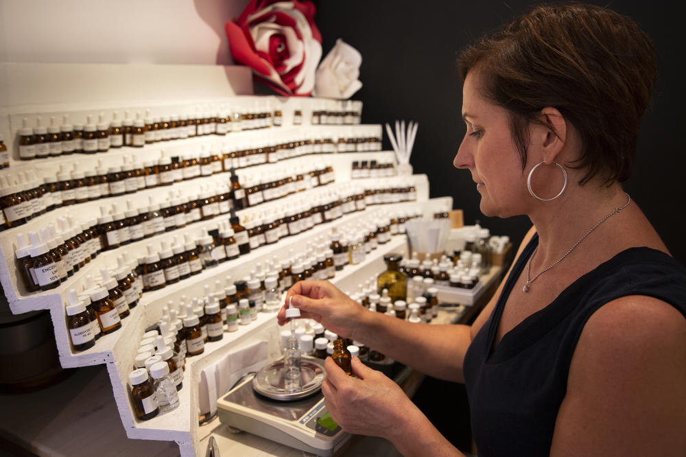 Jessica Buchanan, owner of the 1,000 Flowers shop in Grasse, creates perfumes at her perfumer's organ displaying hundreds of vials of scents.
