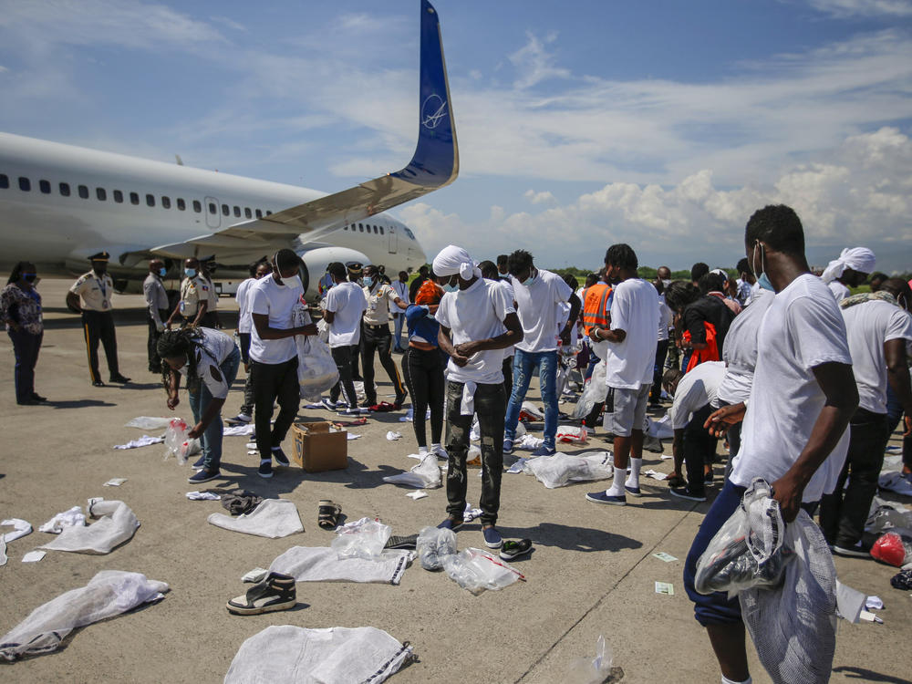 Haitians deported from the U.S. recover their belongings scattered on the tarmac of the Toussaint Louverture International Airport on Tuesday in Port-au-Prince, Haiti.