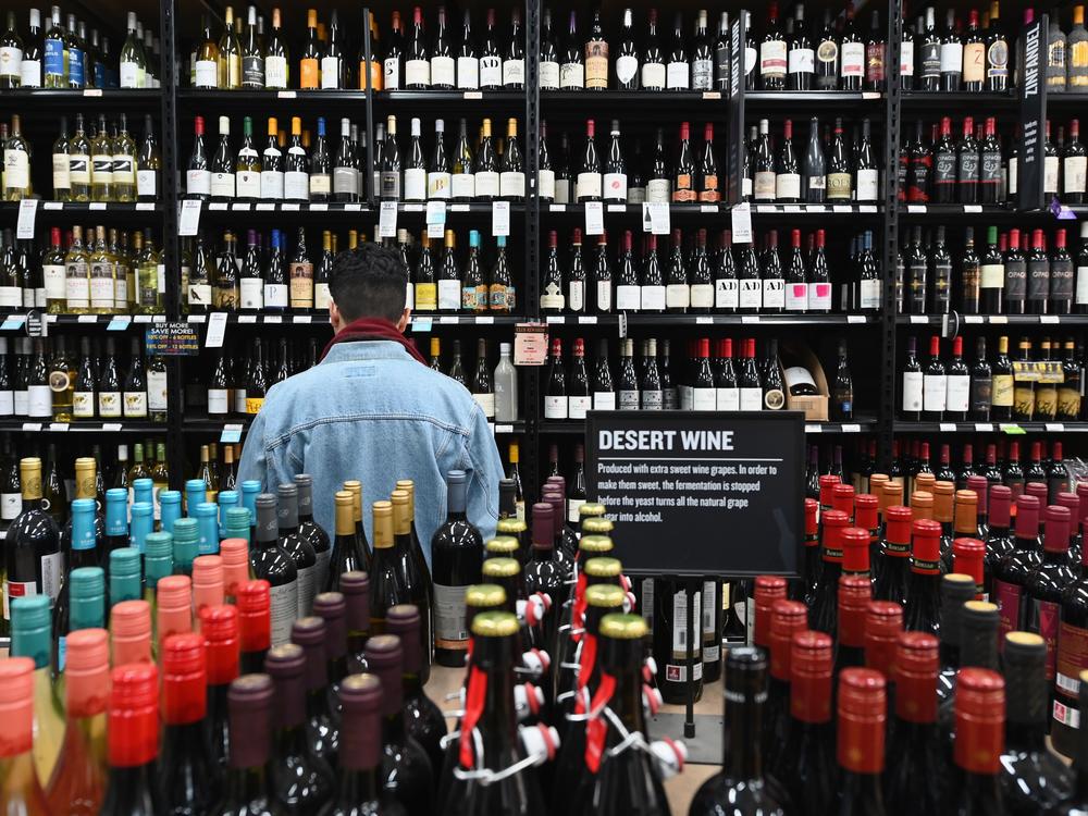A patron stands in front of a shelf of wine bottles at The Liquor Store.Com in Brooklyn, N.Y., last March.