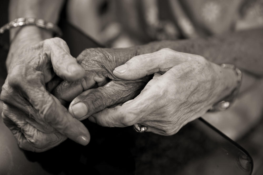 Remedios Tecson and Narcisa Claveria hold hands during a birthday celebration for several of the 