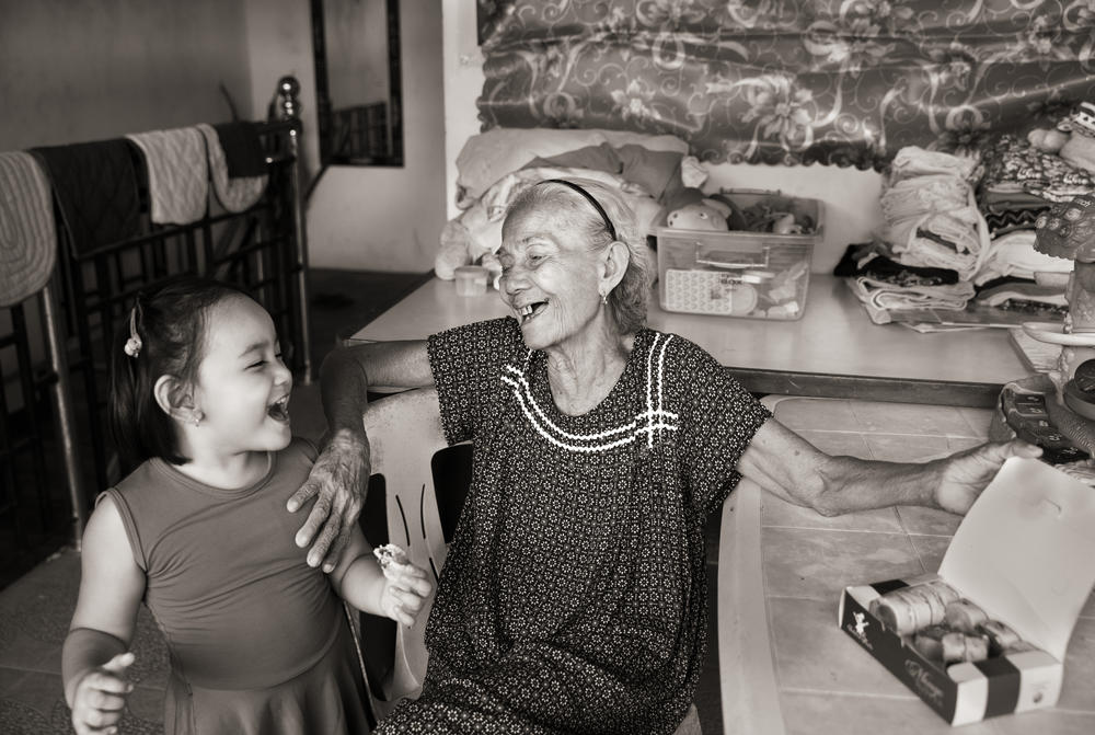 Narcisa Claveria shares a pastry with her great granddaughter, Atarah Mizsha Cancino, at the family's home in Antipolo, Metro Manila.