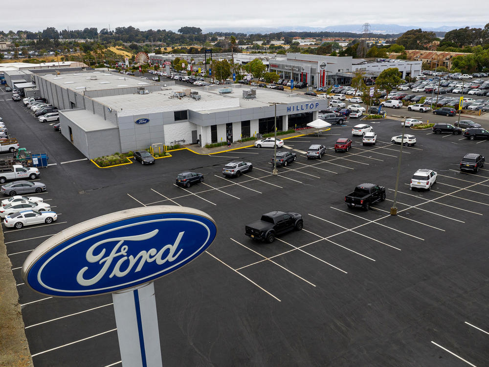 Vehicles sit in a nearly empty lot at a car dealership in Richmond, Calif., on July 1. The global semiconductor shortage has hobbled auto production worldwide, making it difficult to find a car to buy.
