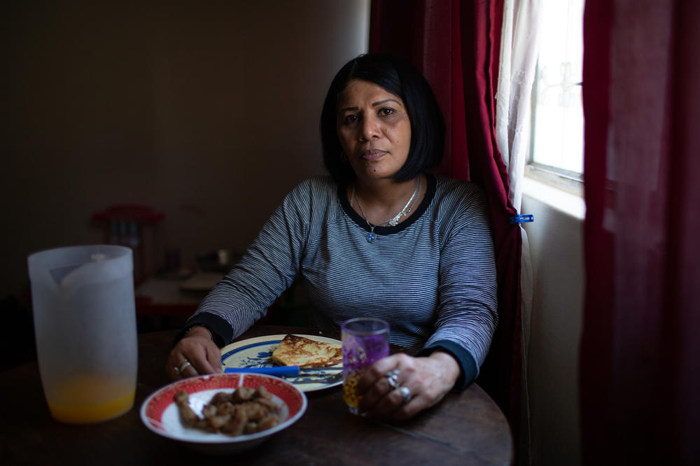 Yroné Camelia Araujo Barreto, a 50-year-old Venezuelan migrant living in Quito, Ecuador. She is eating a traditional Venezuelan dish of <em>cachapa, </em>round dough made from corn, filled with pork. She typically eats two meals a day if she's lucky enough to afford it but says she'll give money or some food to others in need.