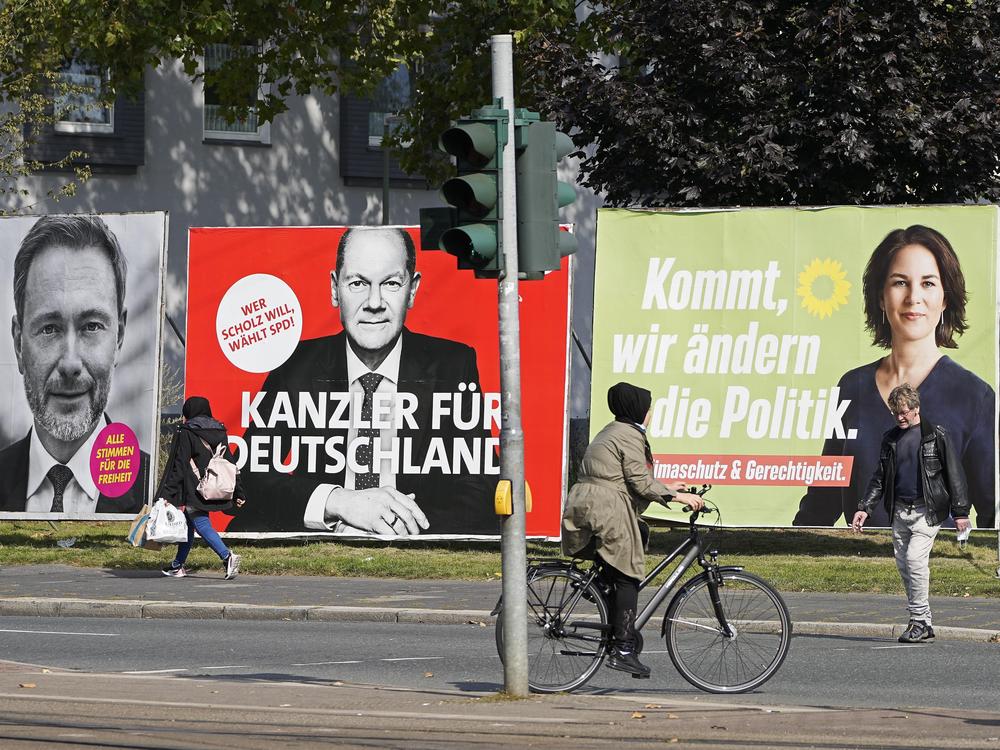 On Thursday, people in Gelsenkirchen, Germany, pass election posters of chancellor candidates Armin Laschet (from right) of the Christian Democratic Union, Annalena Baerbock of the Greens, Olaf Scholz of the Social Democratic Party and Christian Lindner of the Free Democratic Party.